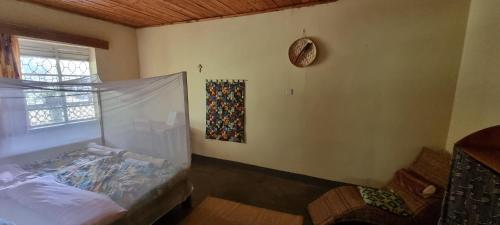 a room with a bed and a window with a curtain at Mutolere Coffee Pot Guest Houses in Kisoro