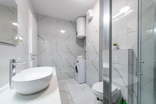 ein Badezimmer mit einem weißen Waschbecken und einer Dusche in der Unterkunft Lupo Gravosa FREE PARKING in Dubrovnik