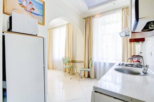 una cocina con nevera y mesa en Apartments De-Ribas, en Odessa