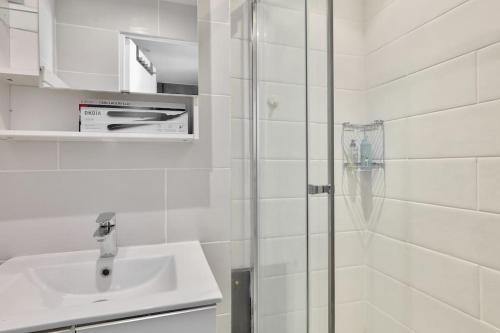 baño blanco con ducha y lavamanos en Superbe T2 au cœur du 17ᵉ arrondissement, en París