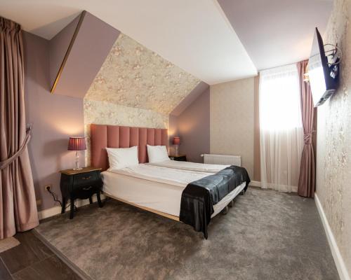 sypialnia z dużym łóżkiem i oknem w obiekcie Torres Poiana w mieście Poiana Brașov