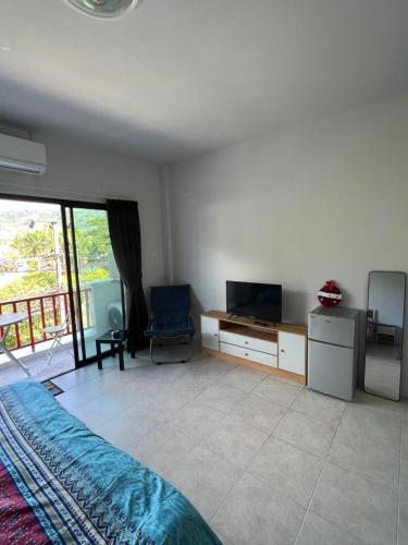 a bedroom with a bed and a tv and a tvicterictericterictericter at Petunya Room 3 in Ban Huai Luk (1)