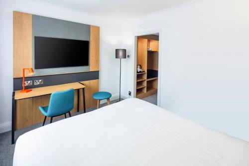 a hotel room with a bed and a tv at Holiday Inn Gloucester - Cheltenham by IHG in Gloucester