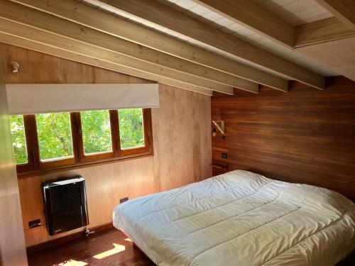 una camera con un letto in una stanza con pareti in legno di Cabaña La Morocha a Ostende