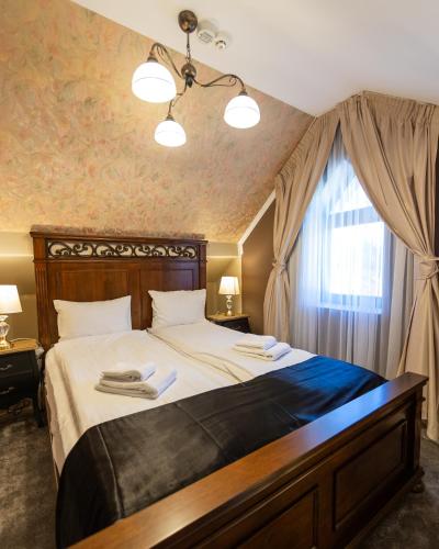 a bedroom with a large bed and a window at Torres Poiana Boutique in Poiana Brasov