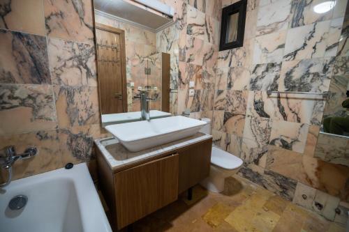 een badkamer met een wastafel, een toilet en een bad bij Al Destino Apartment Luxury Marrakech in Marrakesh
