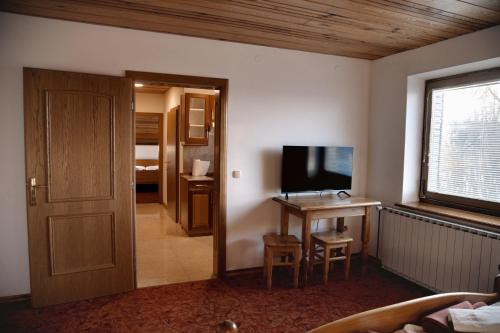 Zimmer mit einem TV und einem Tisch mit einem Schreibtisch. in der Unterkunft Rooms and Apartments Panker in Moravske-Toplice