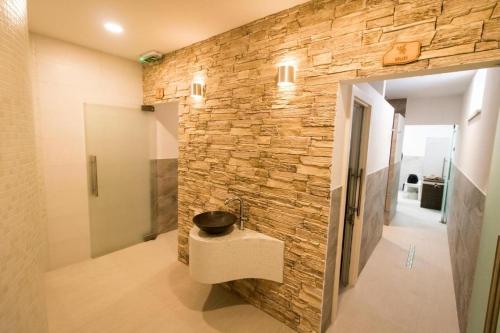 a bathroom with a stone wall with a sink at Apartmány Kľak in Kľačno