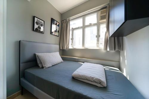 Bett in einem Zimmer mit Fenster in der Unterkunft Student Accommodation - 294 Hennessy Road in Hongkong