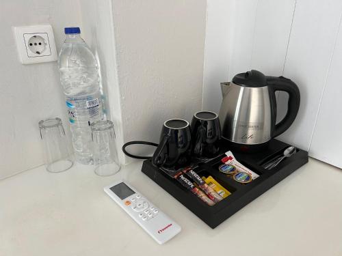 a tray with a coffee maker and a water bottle at Unique Galini Oia - Adults Only in Oia