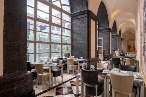 a restaurant with tables and chairs and a large window at Vila Gale Collection S.Miguel in Ponta Delgada