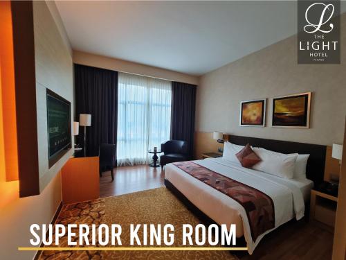 a hotel room with a bed and a television at The Light Hotel Penang in Perai