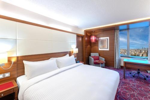 a hotel room with a bed and a desk and a window at Crowne Plaza Amman by IHG in Amman