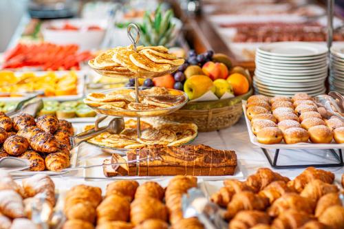 - un buffet de pâtisseries et autres aliments sur une table dans l'établissement Hotel Danieli, à Bibione