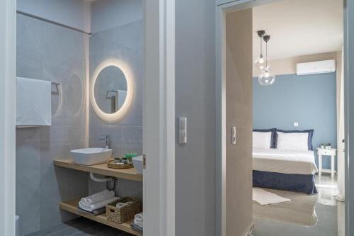 ヘルソニソスにあるNisimos Modern Apartmentの洗面台、ベッド、鏡のあるバスルーム