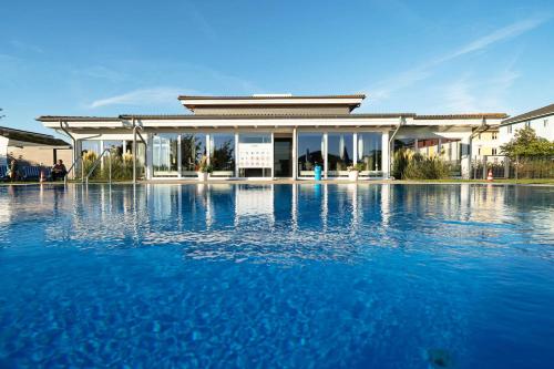 um edifício com uma piscina de água em frente em BEECH Resort Boltenhagen em Boltenhagen