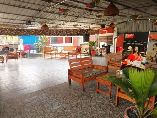 Pokój z drewnianymi ławkami, stołami i stołami w obiekcie Cloud9 Lomé w mieście Lomé
