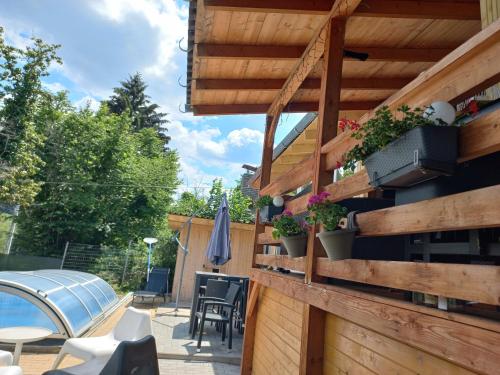 a patio with potted plants on a wooden wall at Onix- Kis-tó Apartman ORFŰ in Orfű