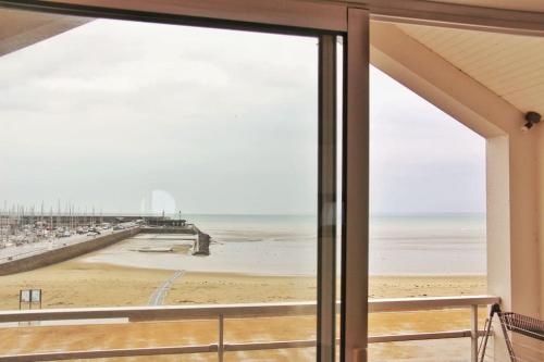 a view of the beach from the window of a house at Un cocon au bord de l'eau in Binic-Etables-sur-Mer