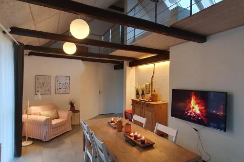 a living room with a table with a fire on it at Centralt by hus Blokhus-Hune til 10 pers privat Gårdhave in Blokhus