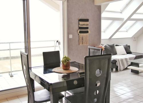 a dining room with a table and a couch at Un cocon au bord de l'eau in Binic-Etables-sur-Mer