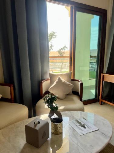 a living room with a chair and a table with a plant at Western Hotel Liwa in Liwa