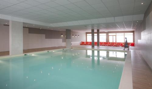 una piscina en una habitación con una persona caminando en ella en Résidence Club mmv L'Étoile des Cimes ****, en Sainte-Foy-Tarentaise