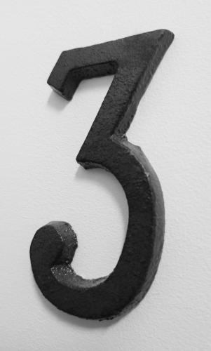 a black number on a white wall at Grand studio lumineux au calme, centre historique in Pertuis