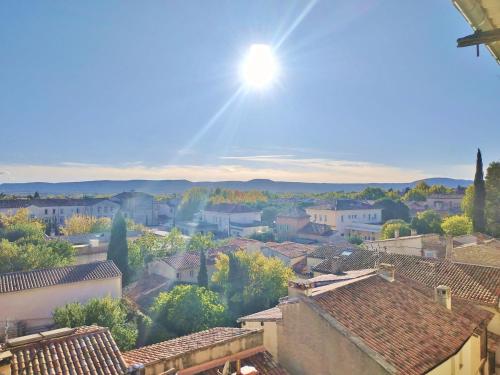 a view of a town with the sun in the sky at Grand studio lumineux au calme, centre historique in Pertuis