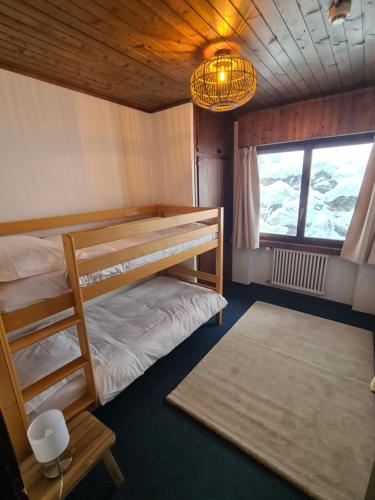 1 dormitorio con 2 literas y lámpara de araña en Auberge de l'Ours, en Les Collons