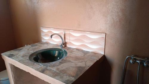 bagno con bancone in pietra e lavandino di Mhamid yaya camp & activités a M'Hamid