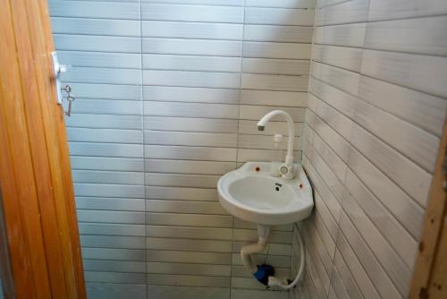 lavabo blanco en el baño con azulejos blancos en 2 Bedroom spacious Cozy Home in Kigamboni,10 min Walk to Beach en Dar es Salaam