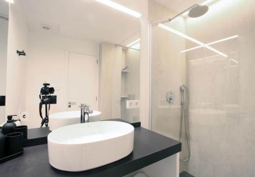 ポルト・ダ・ポリェンサにあるSivella Apartamentoの洗面台とシャワー付きの白いバスルーム