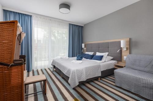 Sunny Apartments in Bel Mare Resort by Renters في مينززدرويه: غرفة نوم بسرير واريكة وكرسي