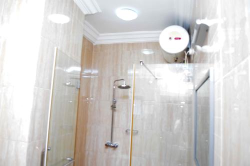 W łazience znajduje się prysznic ze szklanymi drzwiami. w obiekcie Golden Tulip Hotel -GT31 Stadium Road w mieście Port Harcourt