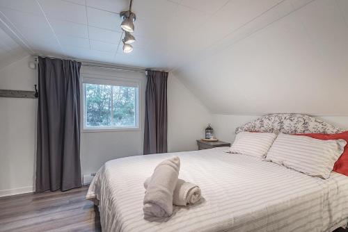Schlafzimmer mit einem großen weißen Bett und einem Fenster in der Unterkunft Stunning Water Front Cocooning et Spa 380 in Chertsey