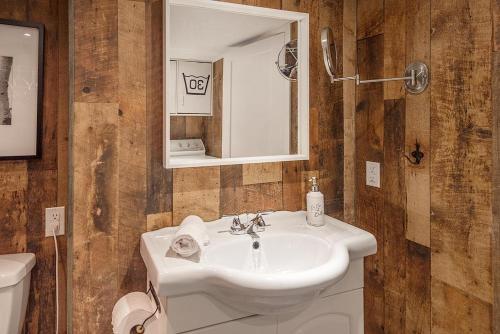 a bathroom with a sink and a toilet and a mirror at Stunning Water Front Cocooning et Spa 380 in Chertsey