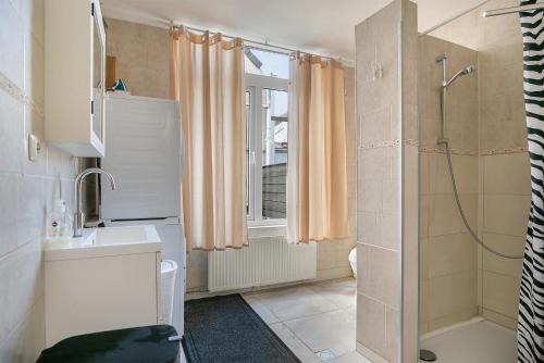 y baño con ducha y lavamanos. en Tourist Travel Inn en Schiedam