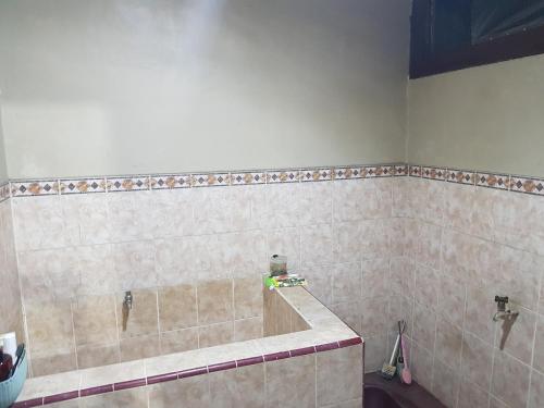 a tiled bathroom with a shower with at Loot's house in Kalianget
