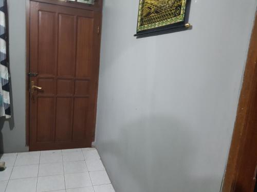 um quarto com uma porta e piso em azulejo ao lado de uma porta em Loot's house em Kalianget