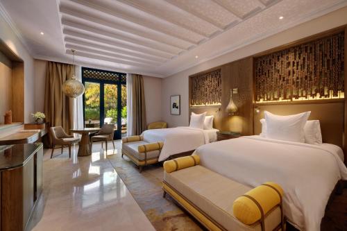 a hotel room with two beds and a living room at Four Seasons Resort Marrakech in Marrakech