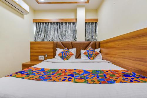 ein Schlafzimmer mit einem Bett mit einem Kopfteil aus Holz in der Unterkunft FabExpress Silver Inn in Ahmedabad