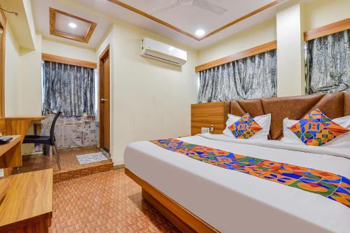 um quarto com uma cama, uma secretária e uma janela em FabExpress Silver Inn em Ahmedabad