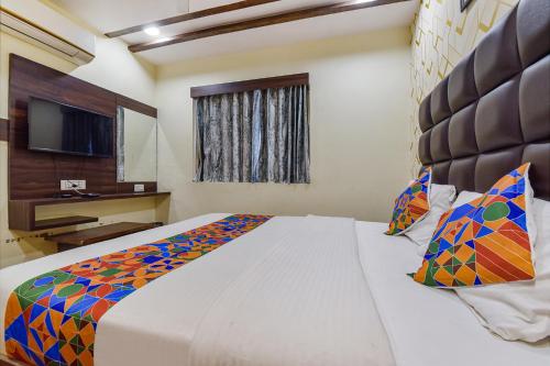 a bedroom with a large bed and a television at FabExpress Silver Inn - CG road in Ahmedabad
