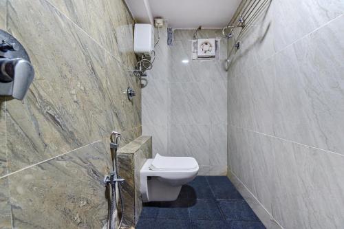 a bathroom with a toilet and a shower at FabExpress Silver Inn - CG road in Ahmedabad
