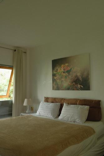 パンガン島にあるArt Hotelの壁に絵が飾られたベッドのある寝室