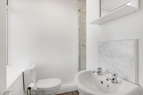 a white bathroom with a toilet and a sink at Dean St Retreat - Cosy Urban Escape, Sleeps 5 in Hexham