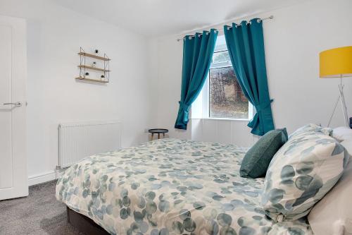 a bedroom with a bed with blue curtains and a window at Dean St Retreat - Cosy Urban Escape, Sleeps 5 in Hexham