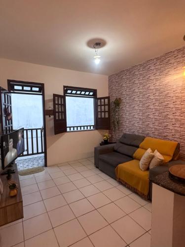 a living room with a couch and some windows at Ap8 atrás da Passarela do caranguejo- Orla de Atalaia in Aracaju