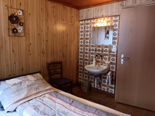 ein Schlafzimmer mit einem Waschbecken und einem Bett in einem Zimmer in der Unterkunft Pension Waldegg - restaurant in Saas-Almagell